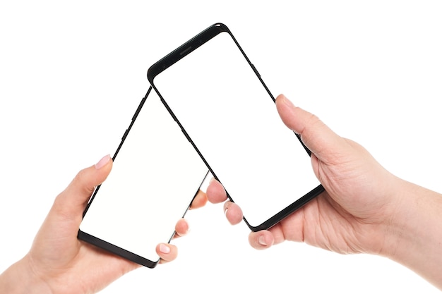 Two hands holding smartphones blank screen with modern frameless design while wireless transferring data NFC connected isolated on white background