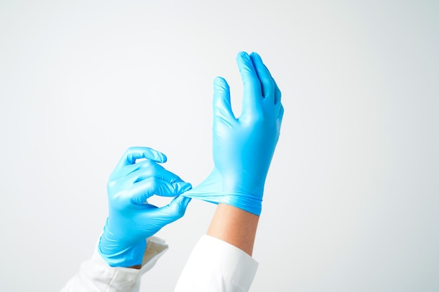 Photo two hands of a man wearing nitrile blue gloves on a white background