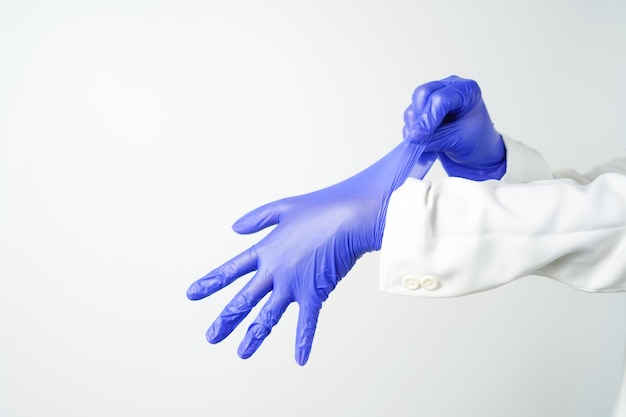 Photo two hands of a man wearing nitrile purple gloves on a white background