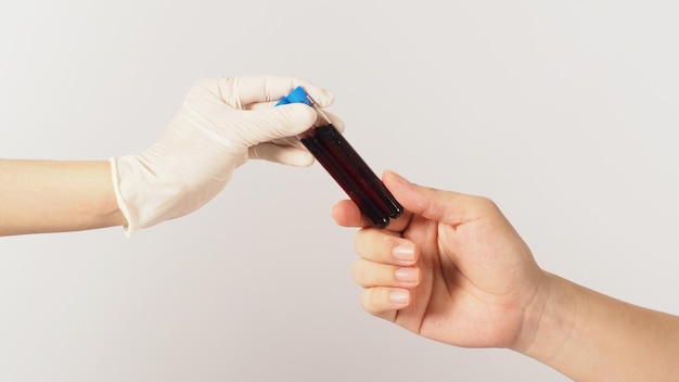 Two hands send and receive two blood test tubes on white background One hand wear latex glove