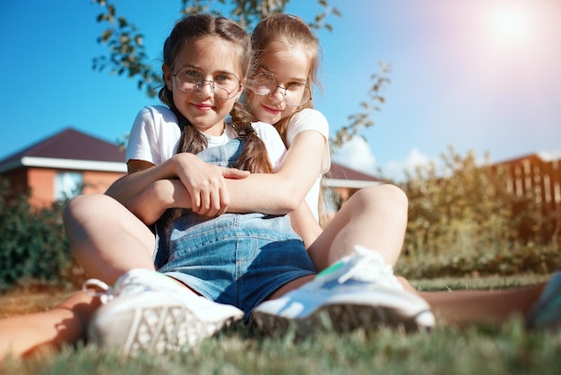 Two happy girls friends in nature Friendly hugs of teenage girls