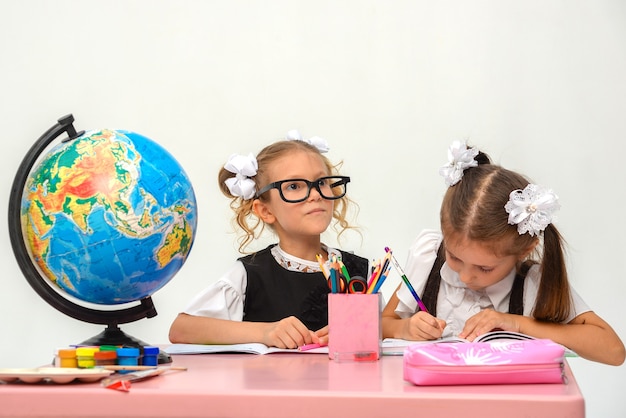 two happy little girls study and write in class isolate