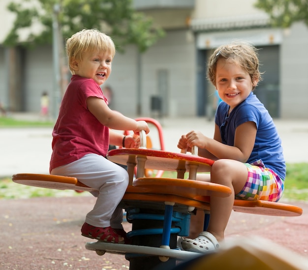 Two happy little sisters on teetering board 