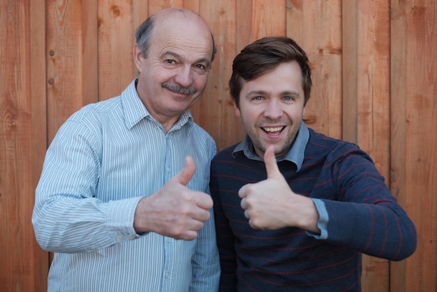 Two happy men giving thumbs up sign