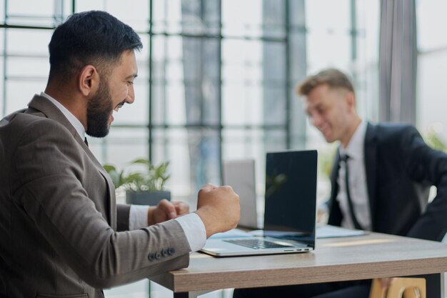 Two happy men working together on a new business project