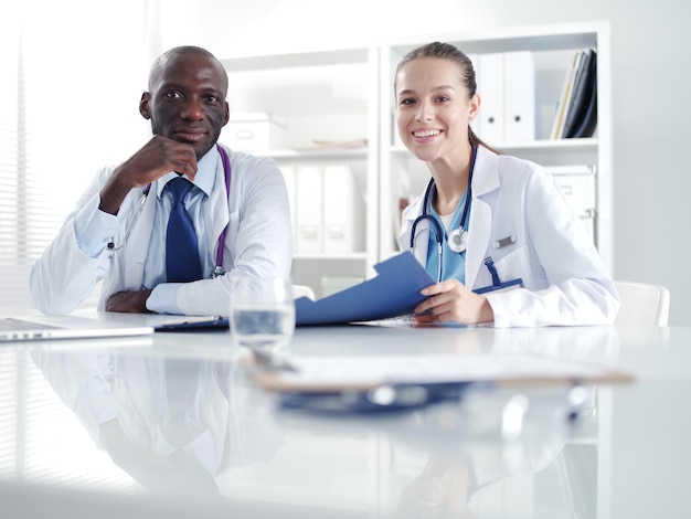 Two happy smiling young medical people handshaking at office Doctors Teamwork