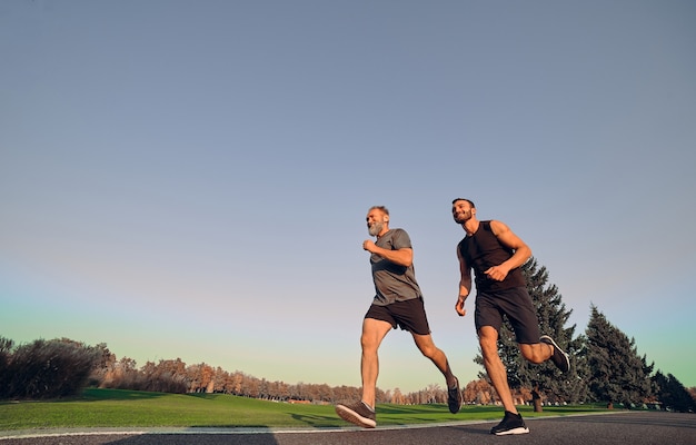 The two happy sportsmen running on the alley