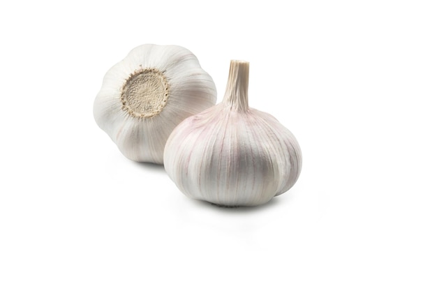 Two heads of garlic laying on white background