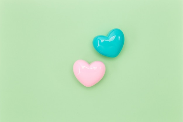 Two heart shapes over green paper