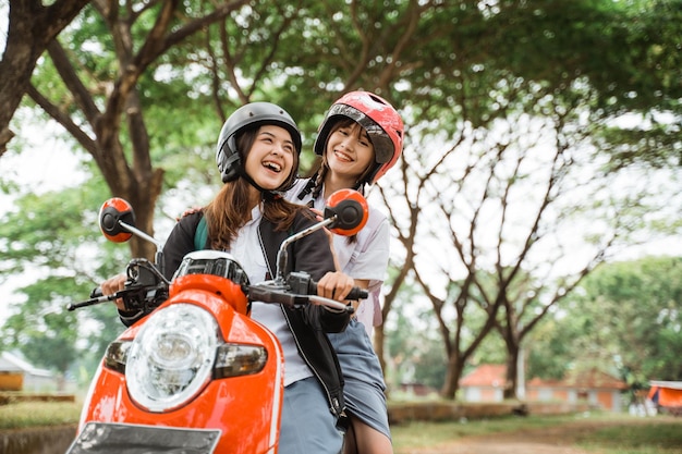 Two high school student girls enjoying a motorcycle ride together