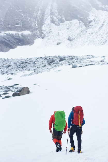 Two hikers walking in winter mountains