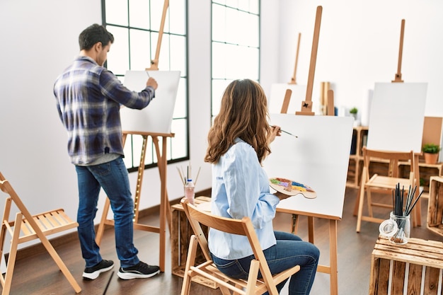 Two hispanic students smiling happy painting at art school