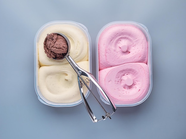 Two ice cream tubs with a scoop isolated on a light background