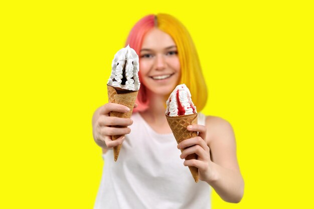 Photo two ice cream in waffle cones closeup in hands of smiling young woman