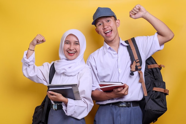 Two Indonesian high school students do winner gesture clenching fist celebrate success