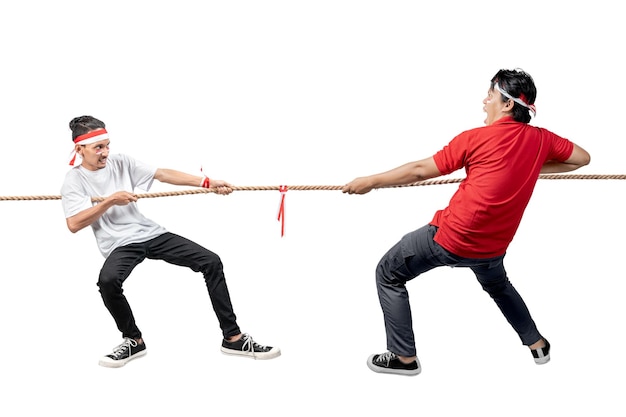 Two Indonesian men celebrate Indonesian independence day on 17 August with the tug of war contest