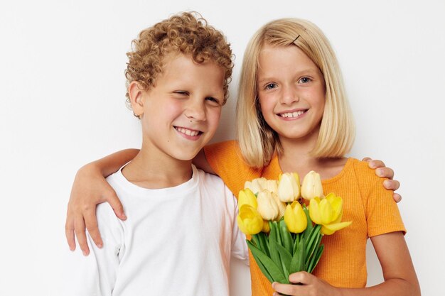 Two joyful children fun birthday gift surprise bouquet of flowers isolated background unaltered