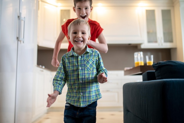 Two joyous boys rushing around the house