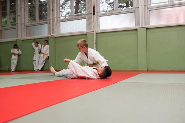 Two judo fighters showing technical skill while practicing martial arts in a fight club The two fit men in uniform fight karate training arts athlete competition conceptSelective Focus