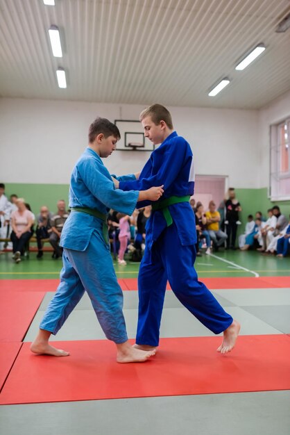 Two judo fighters showing technical skill while practicing martial arts in a fight club The two fit men in uniform fight karate training arts athlete competition conceptSelective Focus