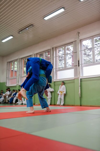 Two judo fighters showing technical skill while practicing martial arts in a fight club The two fit men in uniform fight karate training arts athlete competition conceptSelective Focus