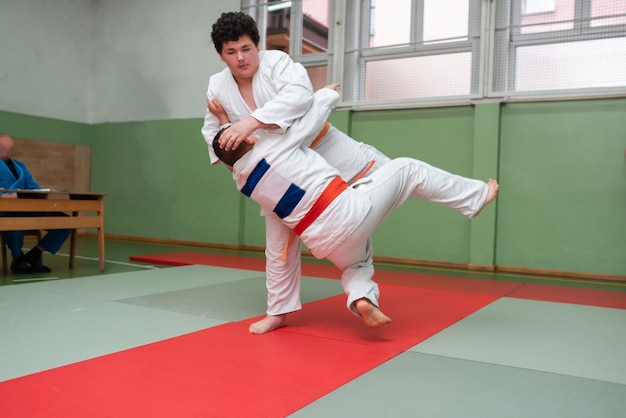 Two judo fighters showing technical skill while practicing martial arts in a fight club The two fit men in uniform fight karate training arts athlete competition conceptSelective Focus