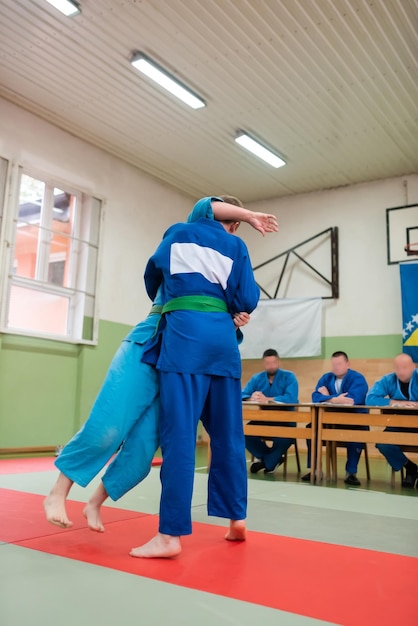 Two judo fighters showing technical skill while practicing martial arts in a fight club The two fit men in uniform fight karate training arts athlete competition conceptSelective Focus