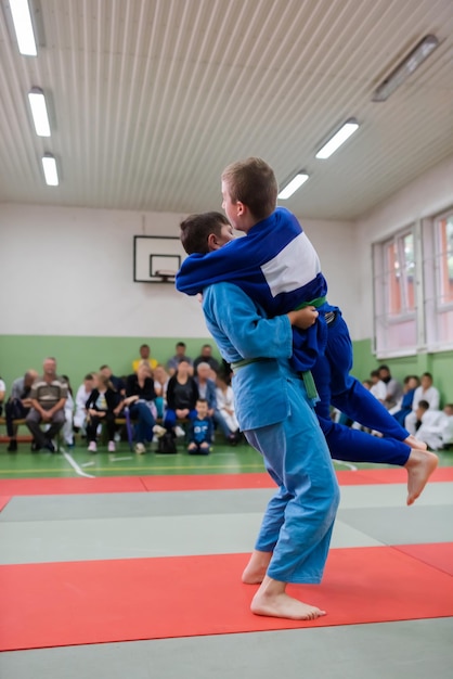 Two judo fighters showing technical skill while practicing martial arts in a fight club The two fit men in uniform fight karate training arts athlete competition conceptSelective Focus