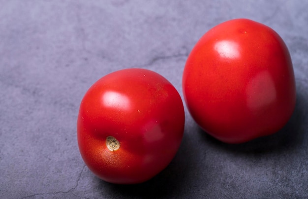 Two juicy red tomatoes on the table