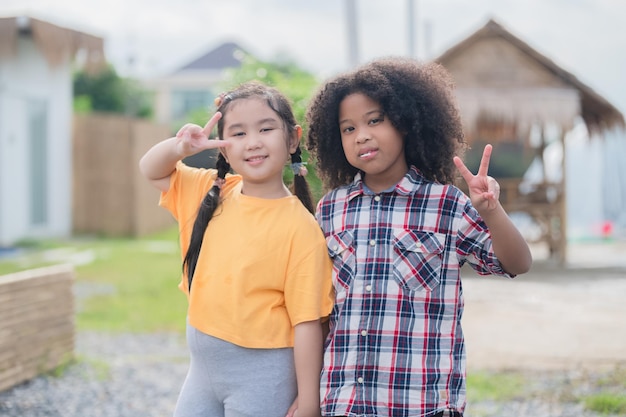 Two kids friends hugging outdoor having fun in summer