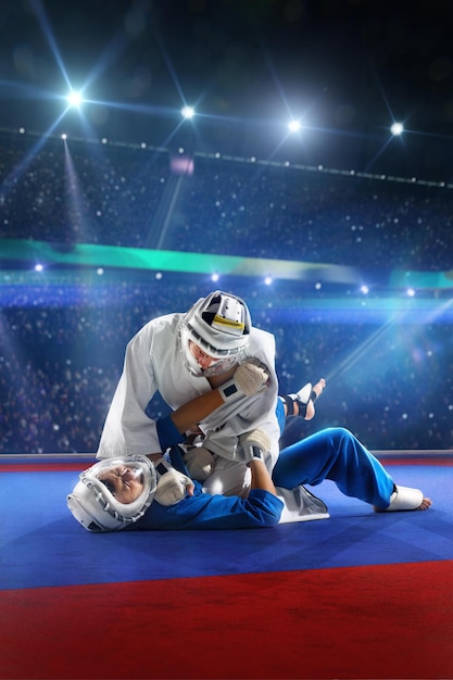 Two kudo fighters are fighting on the grand arena blue and white