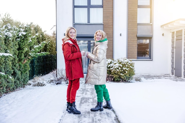 Two ladies posing for the camera outside the house