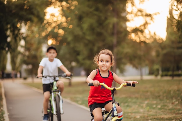 Two little boy and girl cyclists riding their bikes and enjoy having fun Kid outdoors sport summer activity