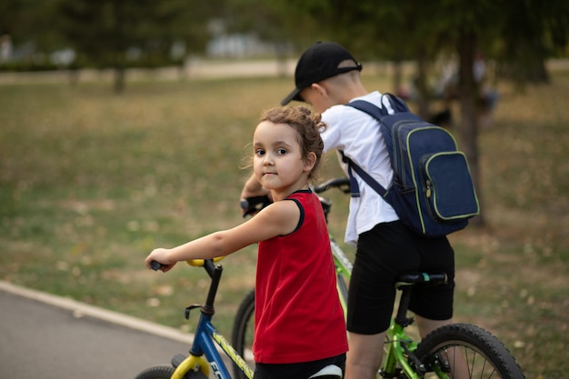 Two little boy and girl cyclists riding their bikes and enjoy having fun Kid outdoors sport summer activity