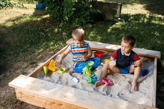 Two little boys playing in the sandbox