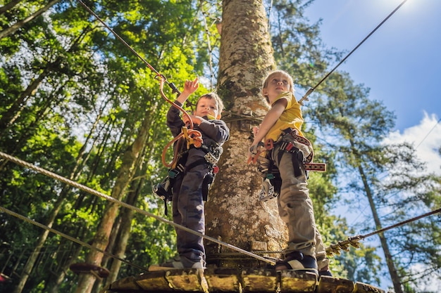 Two little boys in a rope park Active physical recreation of the child in the fresh air in the park Training for children