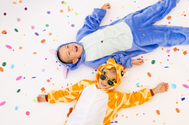 two little brother boys in bright costumes with confetti