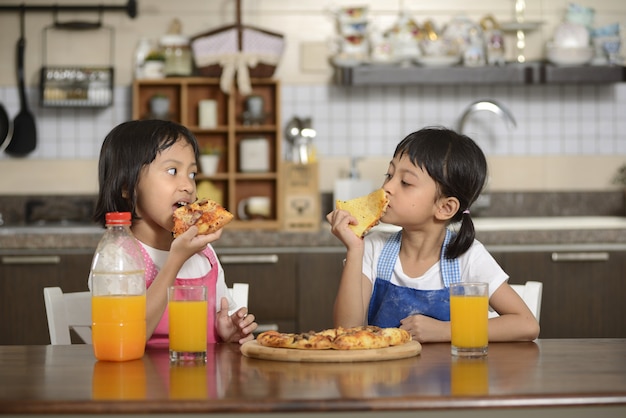 Two Little Girls Eating Pizza