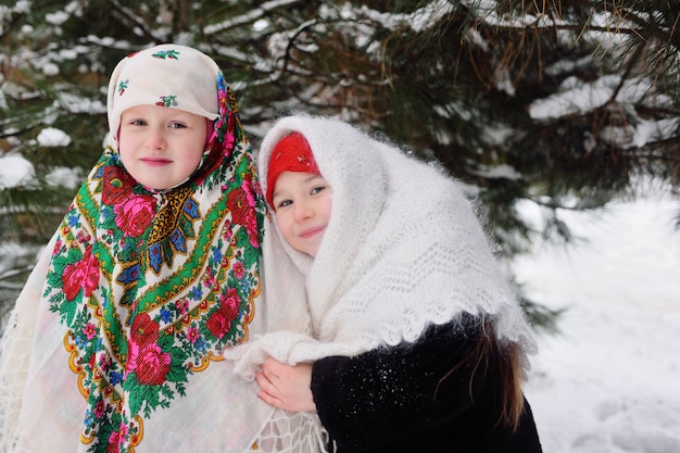 Two little girls in fur coats and Russian scarves