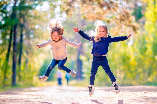 Two little girls jumping outdoors