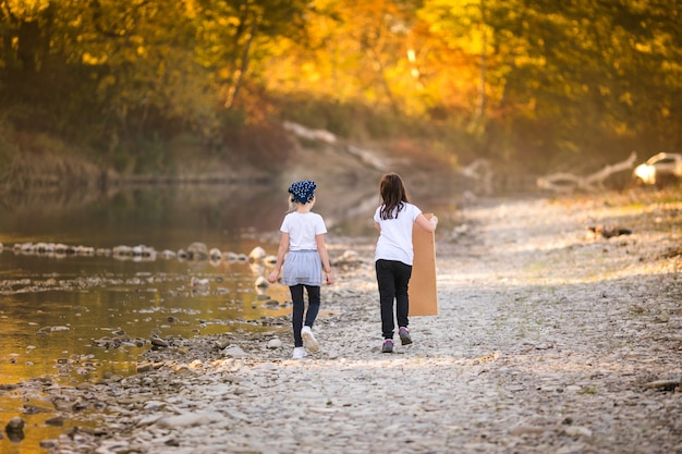 Two little girls playing on the riverside