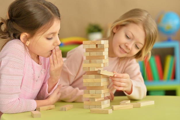 Two little girls playing with wooden plastic blocks