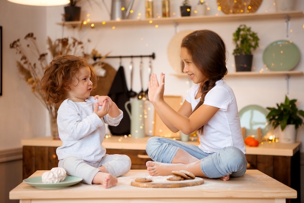 two little girls prepare Christmas cookies in the kitchen