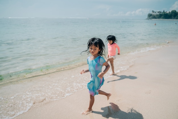 Two little girls running on the beach