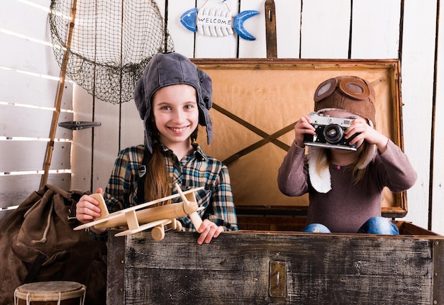 Two little girlspilots in big wooden chest