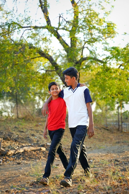 Two little indian brother walking on road