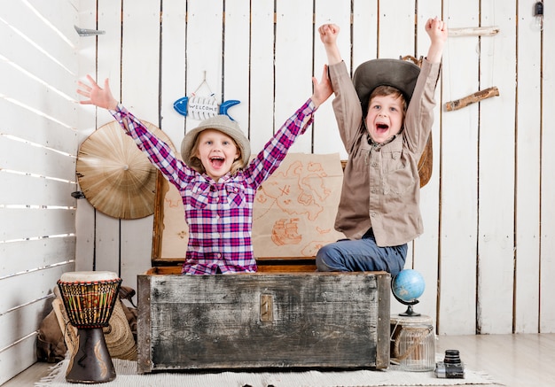 Two little laughing children with hands up