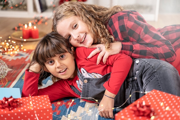 Two little sisters girls playing with gift box in xmas atmosphere