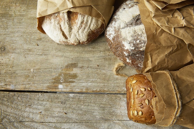 Two Loaves of Bread packed in paper on wooden table