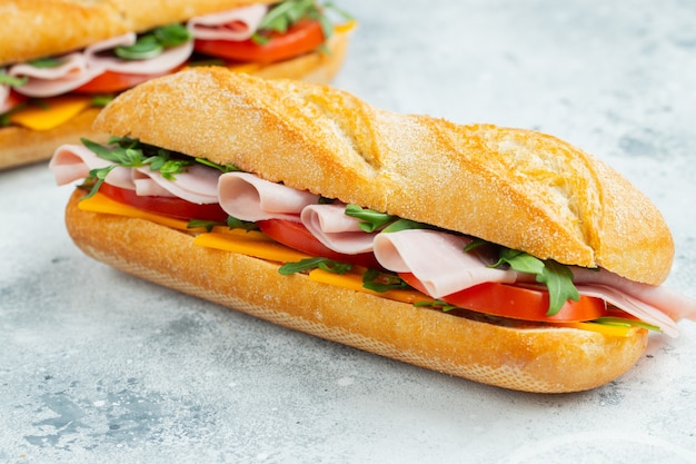 Two long sandwiches with arugula